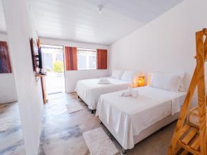 two beds in a room with white walls at Pousada do Enildo in São Miguel dos Milagres +58 photos