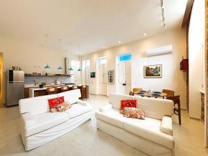 sala de estar con 2 sofás blancos y cocina en Casa Maravilhosa no Coração de Santa Teresa, en Río de Janeiro