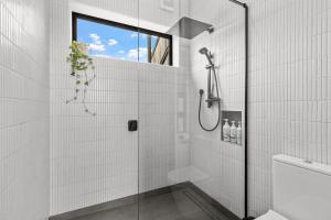 a white bathroom with a shower with a glass door at Seafront, Sauna, Architecture The Surf Nest Full House  +59 photos