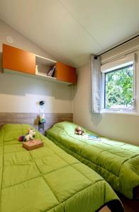 two beds in a room with green sheets at Camping 3 étoiles - ccbc0hb in Pordic
