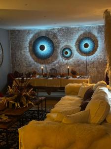 a living room with yellow couches and two blue mirrors at Noelle Mountain Suites in Kalavrita