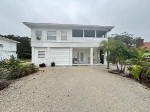 ein weißes Haus mit Kieseinfahrt davor in der Unterkunft Egret - 1st Floor Freshly Updated Kit W&D 3 Miles to Beach in Bonita Springs