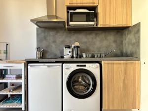 une cuisine avec un lave-linge et un micro-ondes dans l'établissement Le Lis des Pyrénées, à Argelès-Gazost