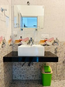 a bathroom with a sink and a mirror at Shells Villa Hikkaduwa in Hikkaduwa