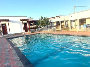 a pool with blue water in front of a building at Marafiki Villa in Dar es Salaam