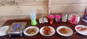 a table with plates of food on top of it at Naviza Homestay in Kepulauan Fam