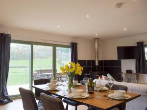 a dining room with a table with yellow flowers on it at Red Kite Lodge - Uk32610 in Old Radnor