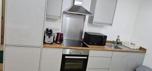 WoolwichにあるModern 1-Bedroom Flat in SE18 10 mins to O2のシンクと電子レンジのある小さなキッチン +2枚の写真