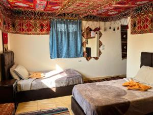 two beds in a room with red and blue ceilings at Kemet Pyramids Room view in Cairo