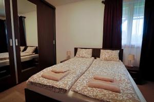 a bedroom with a bed with two towels on it at Csilla Vendégház Remete in Remetea