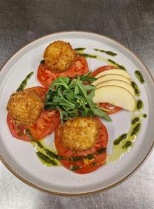 a white plate of food with tomatoes and apple slices at The Swan Hotel in Lydney
