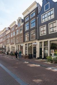 アムステルダムにあるHerenstraat Residenceの二人の建物前の通りを歩く
