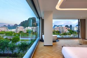 a bedroom with a large window with a tub and a view of a city at Lucky house in Gaotian