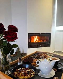 a table with food and a stove with a fireplace at Noelle Mountain Suites in Kalavrita