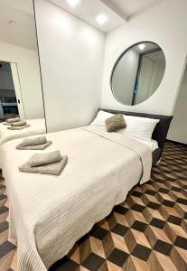 1 dormitorio con 2 camas y espejo en la pared en Amber Circle Apartment Palanga, en Palanga