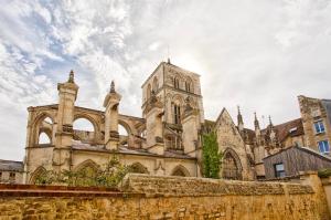 an old stone building with a tower on a cloudy sky at Le Saint-Sauveur - Balneotherapy Bathtub - Hypercentre in Caen
