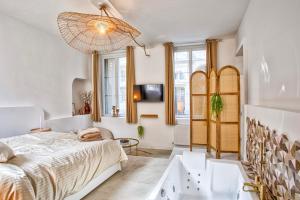 a bedroom with a bed and a tub in it at Le Saint-Sauveur - Balneotherapy Bathtub - Hypercentre in Caen