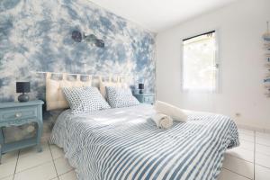 Un dormitorio con una cama con un edredón azul y blanco. en Le Temps de Vivre - Plage - Centre, en La Faute-sur-Mer