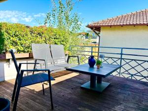 a patio with two chairs and a table on a deck at Lake view, central, terrace in Niederdorla