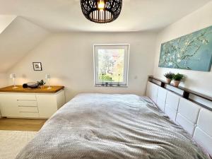 a bedroom with a large bed and a window at Lake view, central, terrace in Niederdorla