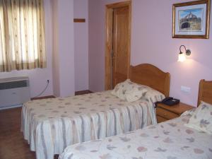 Łóżko lub łóżka w pokoju w obiekcie Hotel Mesón el Castillo