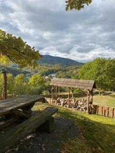 a wooden picnic table in a field with a wooden shelter at Панорама Шаян in Shaian +15 photos