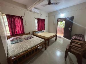 a bedroom with a bed and a table and chairs at Eden homes in Honāvar +14 photos