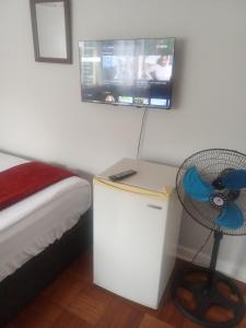 a bedroom with a fan and a tv on the wall at Tranquility Homes in Durban +20 photos