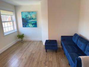 a living room with a blue couch and a window at Union Apartment - Light and Airy in Bedford