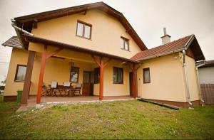 a house with a patio and a table and chairs at Csilla Vendégház Remete in Remetea