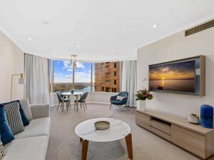 a living room with a couch and a table at The Sebel Quay West Suites Sydney in Sydney +132 photos