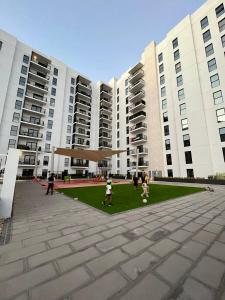 un groupe de personnes jouant au football devant un bâtiment dans l'établissement Relaxing Studio Canal & Pool View Yas Island, à Abu Dhabi