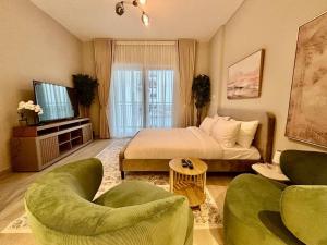 - une chambre avec un lit et deux chaises vertes dans l'établissement Relaxing Studio Canal & Pool View Yas Island, à Abu Dhabi