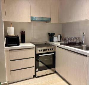 une cuisine avec une cuisinière et un évier dans l'établissement Relaxing Studio Canal & Pool View Yas Island, à Abu Dhabi