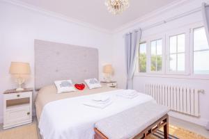 a white bedroom with a bed and two windows at Casa Leo in Playa de Muro +54 photos