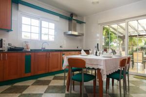 eine Küche mit einem Tisch mit Stühlen und eine Küche mit Fenstern in der Unterkunft Los Vicentes in Playa Honda