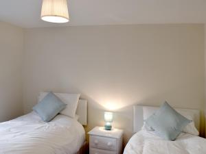 two beds sitting next to each other in a room at 1 Greta Side Court in Keswick