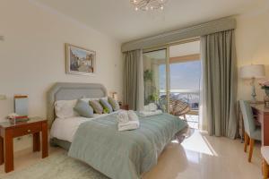 une chambre avec un lit, un bureau et une fenêtre dans l'établissement Luxury Burgau Penthouse, à Burgau