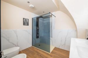 a bathroom with a toilet and a glass shower at Hidden church in Chiusa di Pesio
