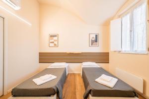 two beds sitting in a room with a window at Hidden church in Chiusa di Pesio