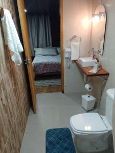 a bathroom with a bed and a toilet and a sink at Casa no Bosque Vila Natal in Campos do Jordão