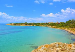 a view of a beach with blue water at White & Black Aegina - Private Garden & Parking in Áyioi Asómatoi