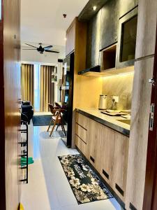 a kitchen with wooden cabinets and a counter top at Flysleep Apartemen Pollux Habibie Batam 1BR Sea View n City in Batam Center