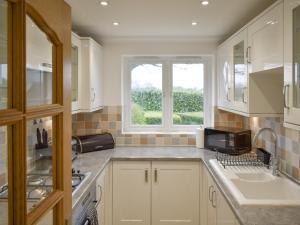 a kitchen with a sink and a window at The Nest in Aldringham +6 photos