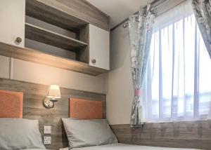 a bedroom with a bed and a window at Golden Palm Resort in Chapel Saint Leonards