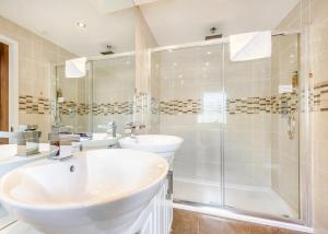 une salle de bain avec une baignoire, un lavabo et une douche dans l'établissement Herons Brook Retreat Lodges, à Narberth