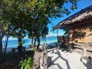 a hut on the beach next to the water at Naviza Homestay in Kepulauan Fam