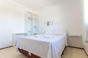 a white bedroom with a bed with white sheets at Beach Townhouses - Porto das Dunas By Carpediem in Mangabeira +79 photos