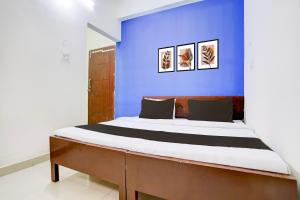 un lit dans une chambre avec un mur bleu dans l'établissement Hotel O Shree Mayaa, à Gwalior