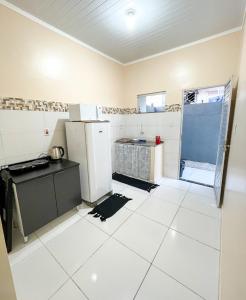 a kitchen with white tile floors and a refrigerator at Casa em Condomínio, Jardim, Home Office in Castanhal